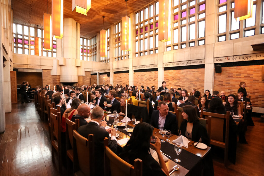 People having dinner at long tables at Massey College