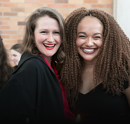 Two Massey College students hug and smile for the camera
