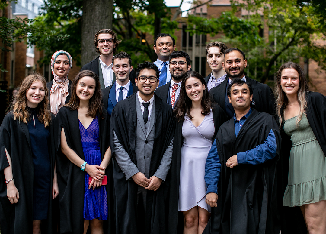 A group of students stand proudly together smiling for the camera